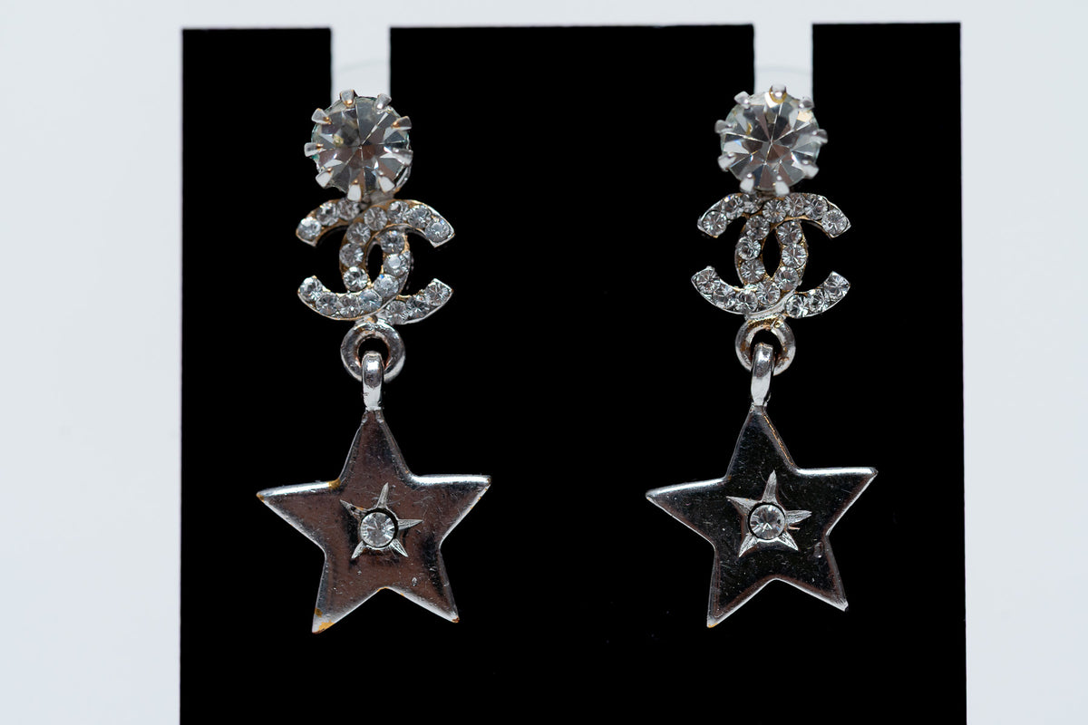silver tone star drop earrings with crystal embellished logo (close up)