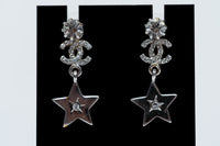 silver tone star drop earrings with crystal embellished logo (close up)
