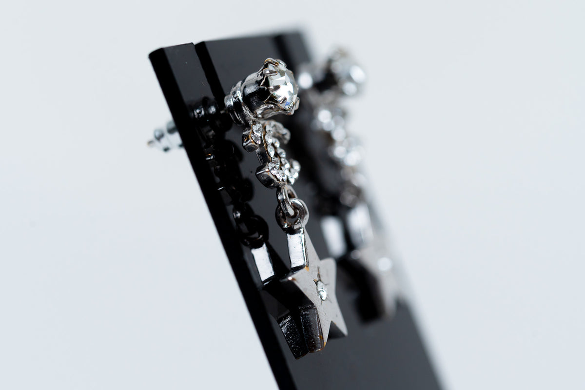 silver tone star drop earrings with crystal embellished logo (side)