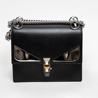 Black Fendi handbag with chain strap on a white background
