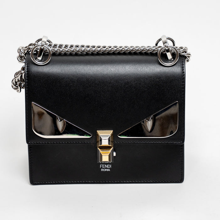 Black Fendi handbag with chain strap on a white background