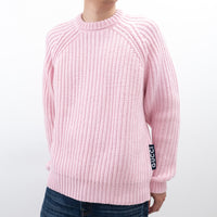 Pink sweater with Gucci logo on sleeve against a white background