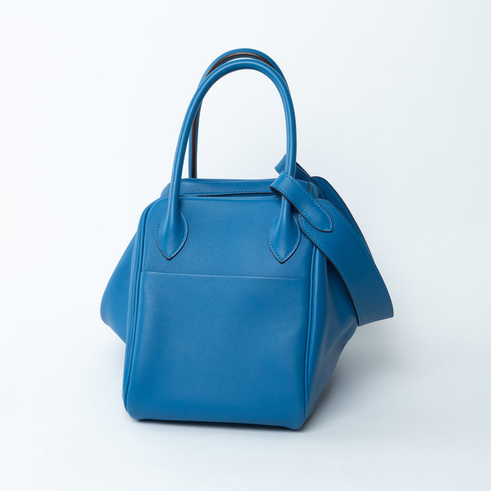 Blue handbag with a strap on a white background