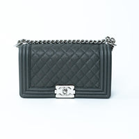 Chanel Medium Boy Bag in Grey quilted handbag with a silver chain and clasp on a white background