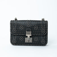 Dior Black handbag with silver studs and Dior logo on a white background