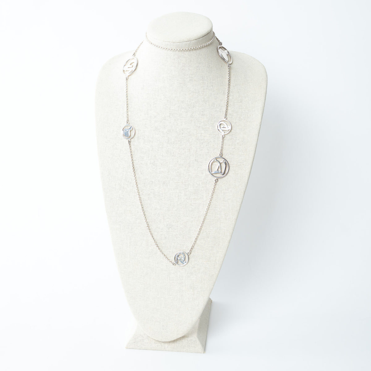 Hermes long silver necklace on a mannequin bust against a white background