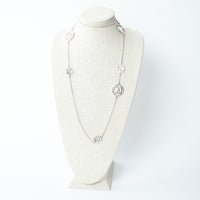 Hermes long silver necklace on a mannequin bust against a white background