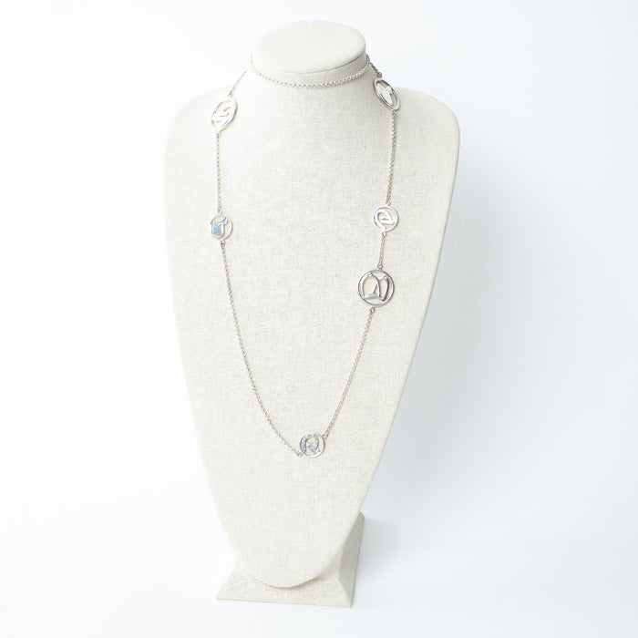 Hermes long silver necklace on a mannequin bust against a white background