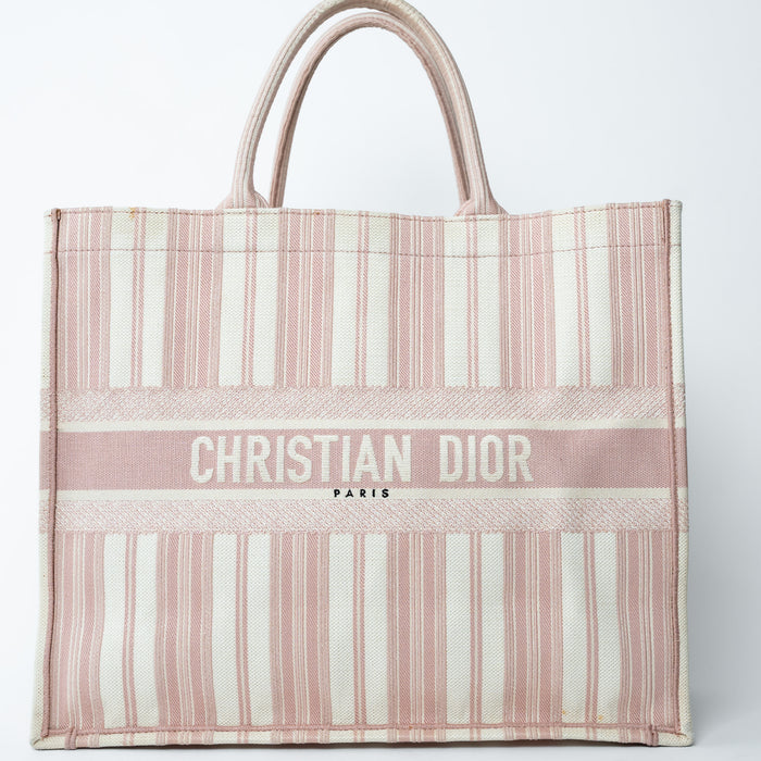 Striped tote bag with 'Christian Dior' branding on a light gray background
