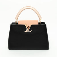 Black handbag with pink handle and logo on a white background