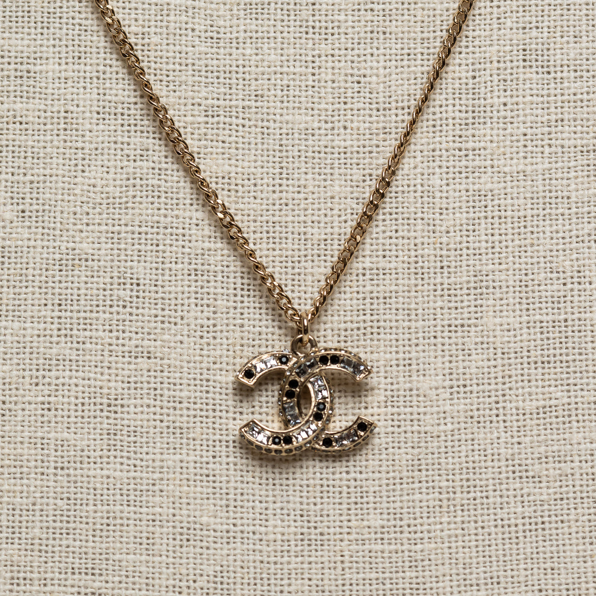 Pre-Loved Chanel™ Gold Tone Logo Pendant Necklace Inset with Clear and Black Crystals