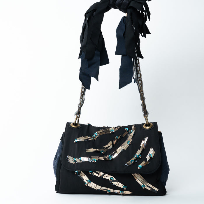 Black silk handbag with decorative elements on a white background