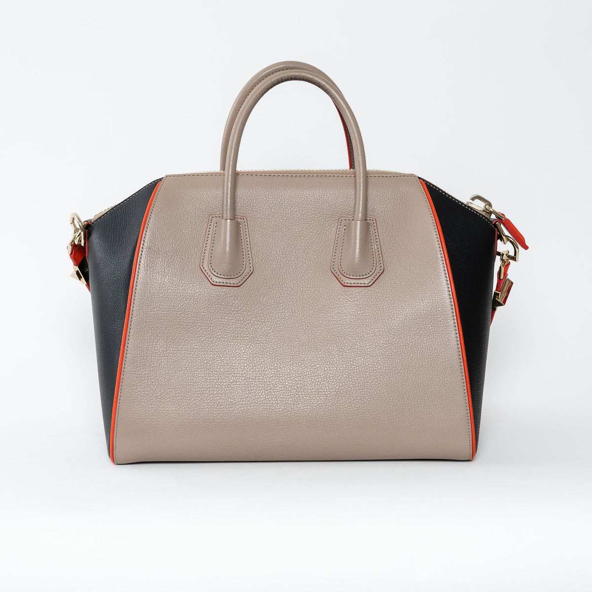 Multicolored handbag with beige, black, and orange sections on a white background