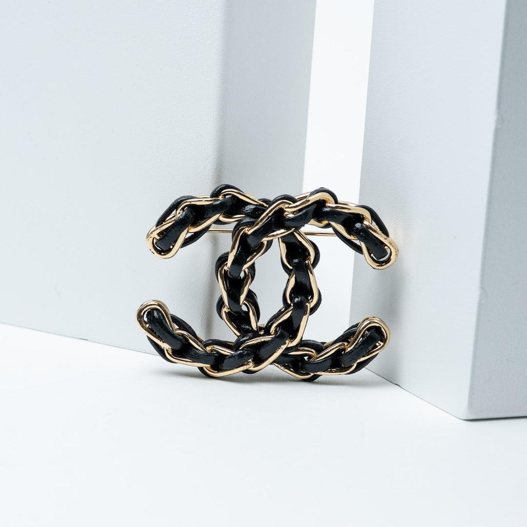 Black and Gold-Tone Leather Logo Brooch. (front)