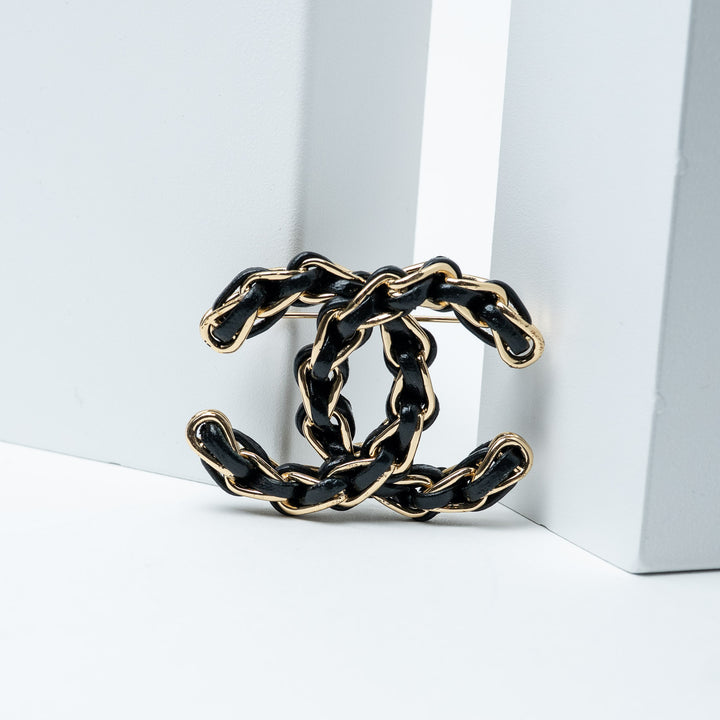 Black and Gold-Tone Leather Logo Brooch. (front)