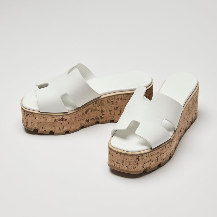 White sandals with cork soles on a light gray background