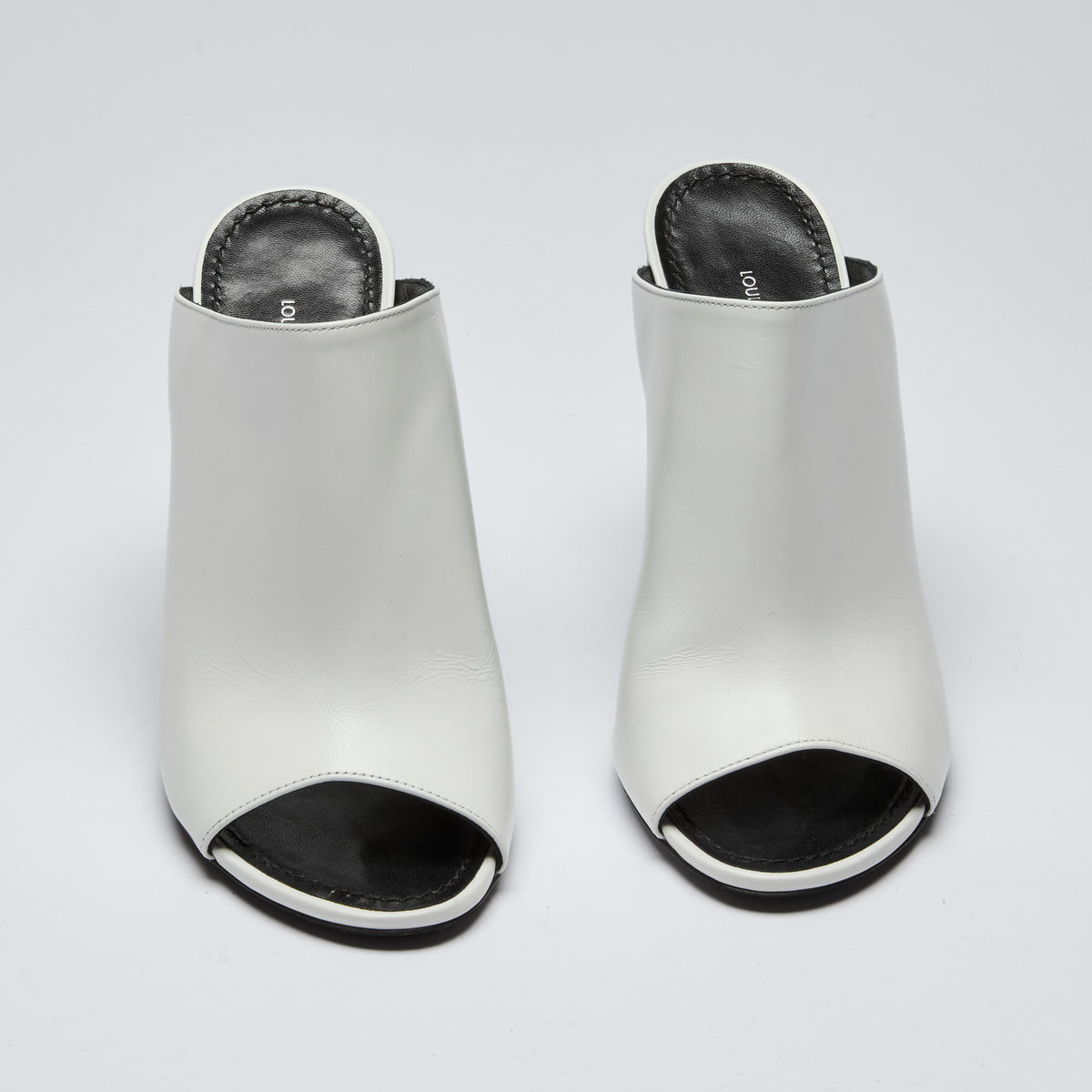 Excellent Pre-Loved White Leather and Black Enameled Block Heel Peep Toe Mules with Oversized Logo Etched on Backside of Heels. (Front)