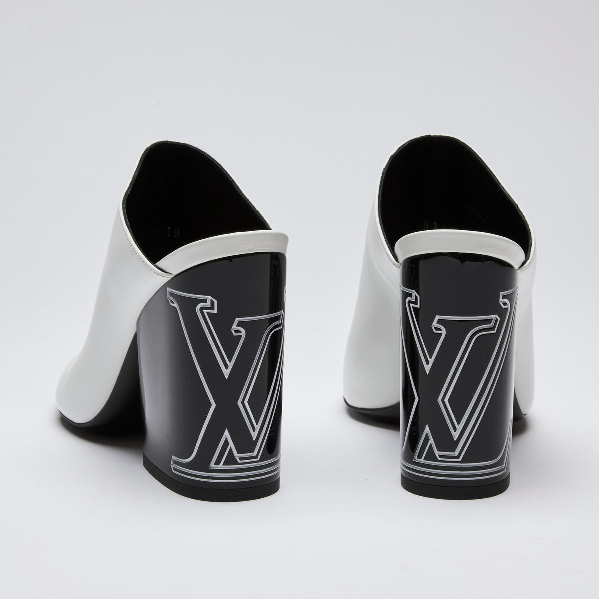 Excellent Pre-Loved White Leather and Black Enameled Block Heel Peep Toe Mules with Oversized Logo Etched on Backside of Heels. (back)