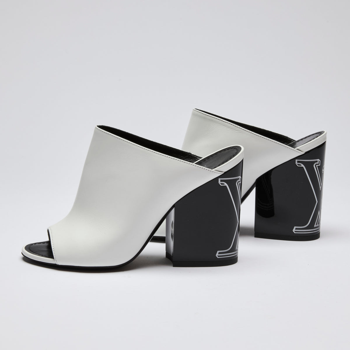 Excellent Pre-Loved White Leather and Black Enameled Block Heel Peep Toe Mules with Oversized Logo Etched on Backside of Heels.  (side)