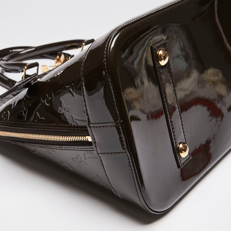 Pre-Loved Dark Plum Monogram Embossed Patent Leather Top Handle Bag. (corner)